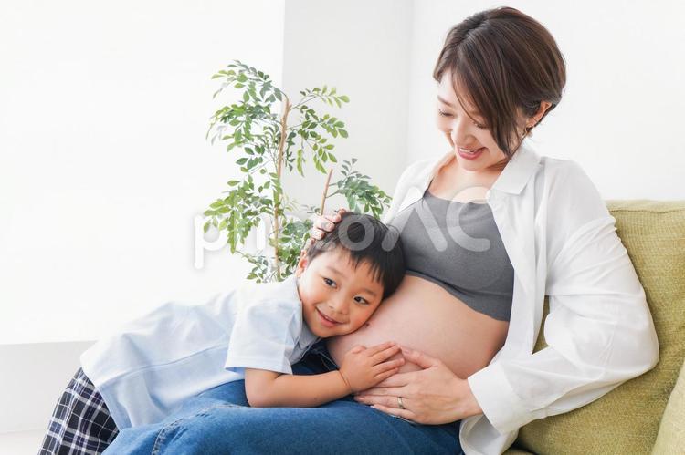 赤ちゃんの鼓動を聞く小さな男の子 幼児,産婦人科,お母さんの写真素材