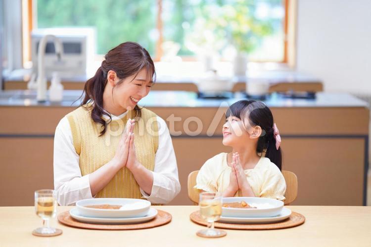 見つめ合いいただきますをする親子 母,娘,食事の写真素材