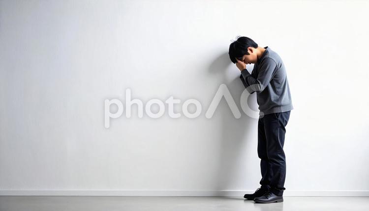 壁に寄りかかる落ち込んでいる日本人男性 孤独,男性,落ち込みの写真素材