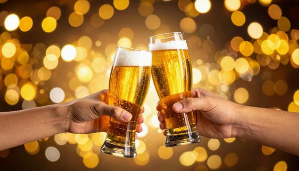 グラスビールで乾杯する男女の手元 グラスビールで乾杯する男女の手元の写真