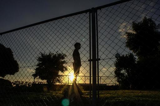 <素材>運動後夕日を背に立ち尽くす男の子 <素材>運動後夕日を背に立ち尽くす男の子 子供,男性,人物の写真素材