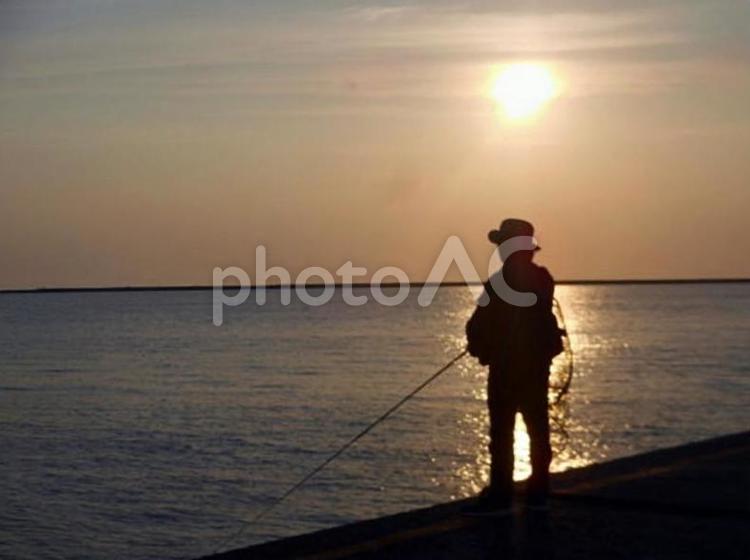 夕日を浴びる釣り人 風景,夕日,海の写真素材