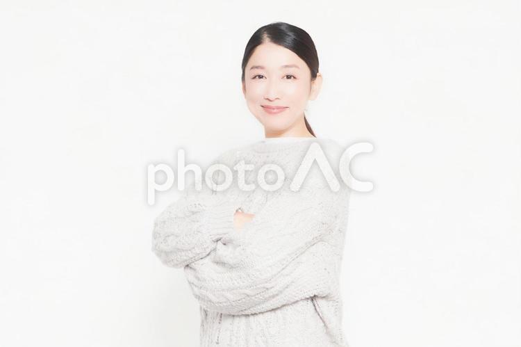 白背景の前で腕組みをしている笑顔の女性 腕組み,笑顔,女性の写真素材