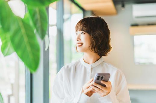 スマホを使う笑顔の女性・ビジネスウーマン スマホを使う笑顔の女性・ビジネスウーマン 女性,スマホ,スマートフォンの写真素材