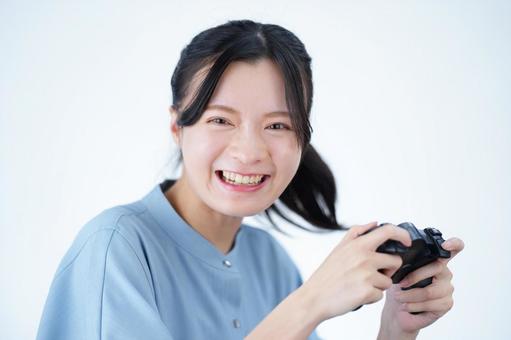 女性がゲームを楽しんで笑顔を見せる 女性,ゲーム,コントローラーの写真素材