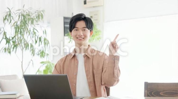 パソコンを使いながら指差しをする男性 男性,指差し,ポイントの写真素材