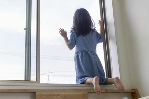窓から外を見る女の子の後ろ姿(5歳) 窓から外を見る女の子の後ろ姿(5歳) 女の子,後ろ姿,窓の写真素材