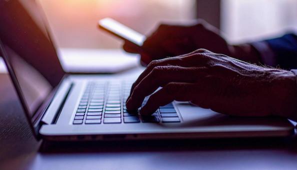 デスクワーク　パソコンに両手で入力するの写真