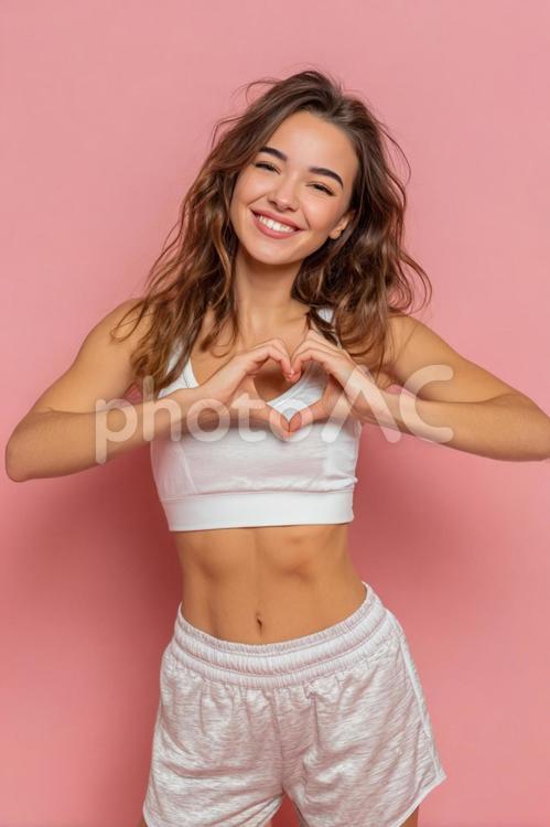 ハートサインを見せる笑顔の女性 女性,女の子,フィットネスの写真素材