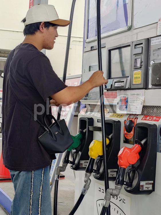 ガソリンを給油する直前に戸惑う男性 ガソリン,ガソリンスタンド,給油の写真素材