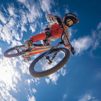 屋外で高く飛ぶプロBMXスタントライダー 屋外で高く飛ぶプロBMXスタントライダーの写真