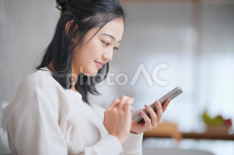 スマホを見つめる女性の横顔 女性,スマホ,日本人の写真素材