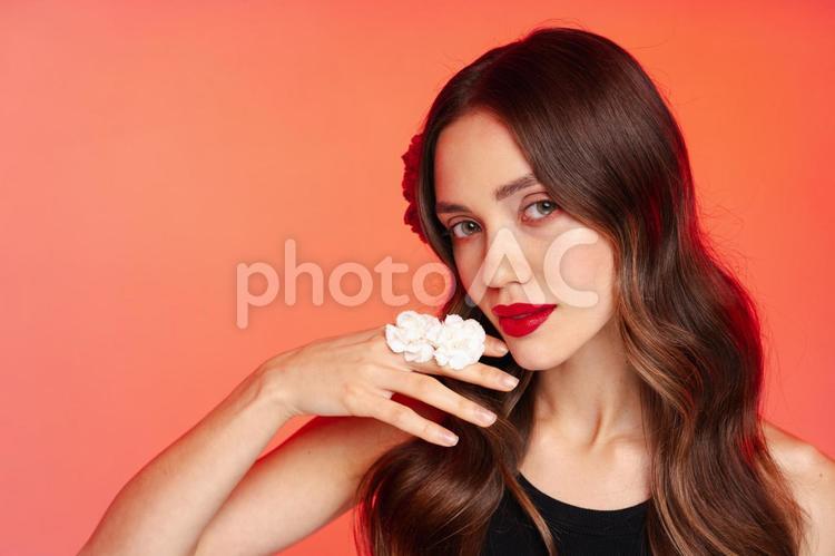 指に白い花をつけた赤い口紅の女性 女性,花,指の写真素材