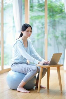 バランスボールに座り困った顔の女性 女性,バランスボール,困るの写真素材