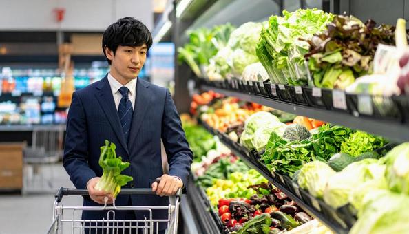 スーパーで野菜を買う日本人ビジネスマン スーパーで野菜を買う日本人ビジネスマンの写真