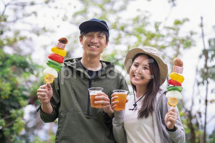 バーベキューする男女（キャンプ） バーベキュー,ビール,キャンプの写真素材