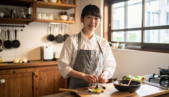 レストランの調理場で料理するスタッフ女性の写真