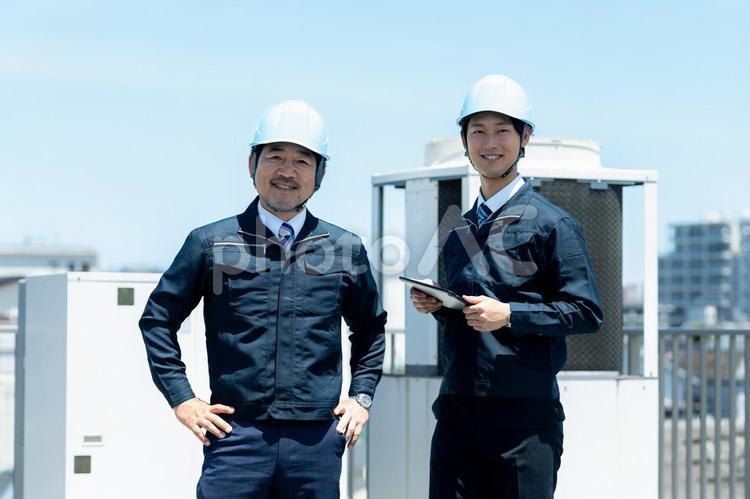 現場で打ち合わせする作業服のビジネスマン 作業服,笑顔,打ち合わせの写真素材