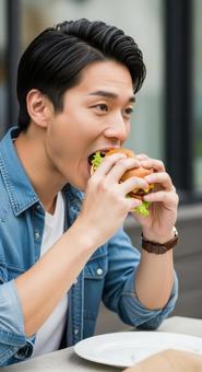 ハンバーガーを食べる男性のアップ写真 ハンバーガーを食べる男性のアップ写真の写真