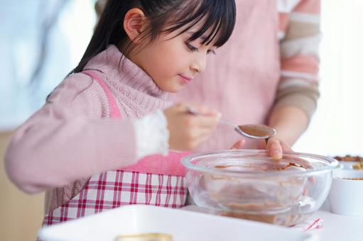 ボウルからチョコをすくって型に入れる手元 女の子,チョコレート,スプーンの写真素材