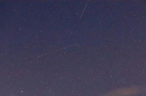 秋の夜空の流れ星2と飛行機の残光の写真