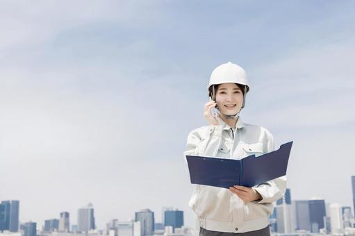 A young woman in work clothes using a smartphone, JPG