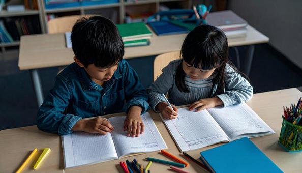 学校の教室で勉強している小学生2人 学校の教室で勉強している小学生2人の写真
