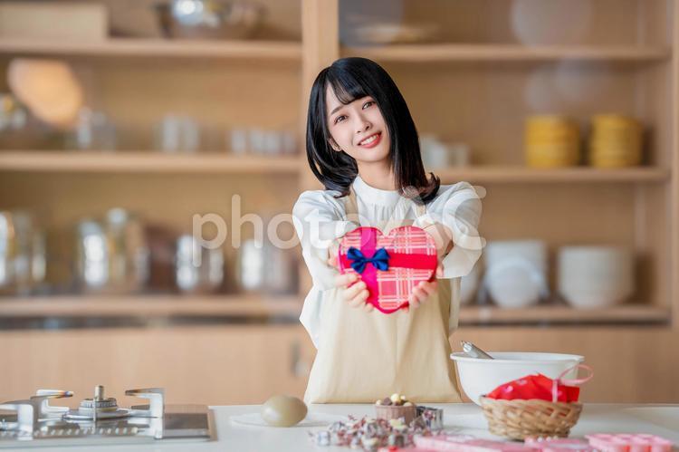 微笑みながら本命チョコを差し出す女性 バレンタイン,バレンタインデー,チョコの写真素材