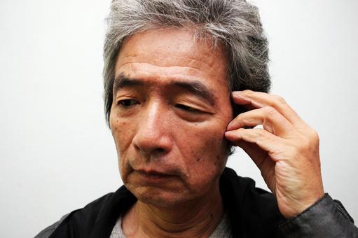 悩むシニア男性 悩むシニア男性の写真