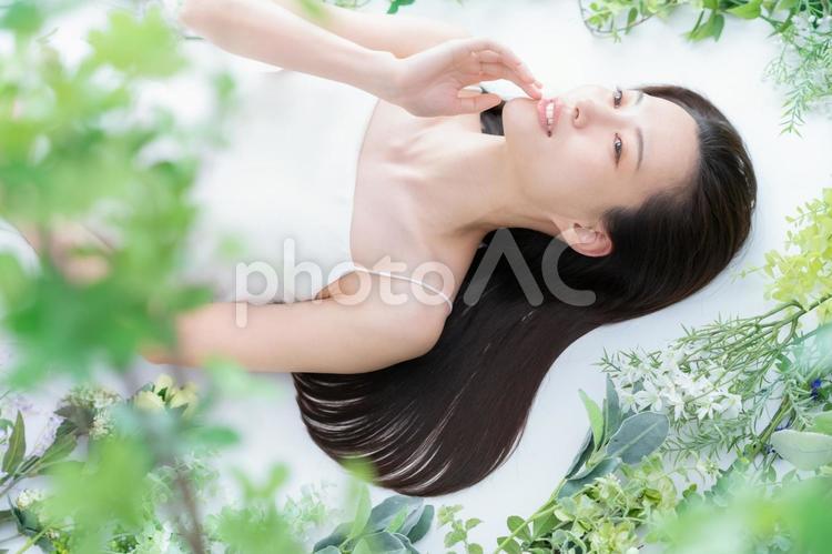 緑の中でスキンケアをする若い女性 ビューティー,女性,スキンケアの写真素材