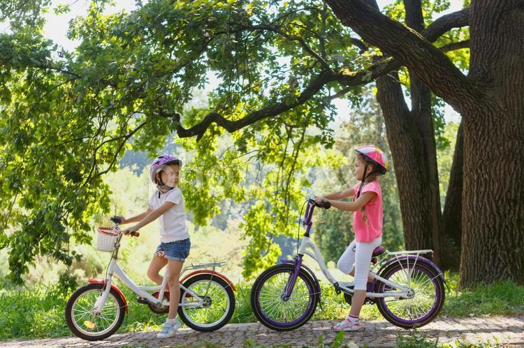 自転車にまたがっている2人の横向きの女の子たち 自転車,子ども,女の子の写真素材