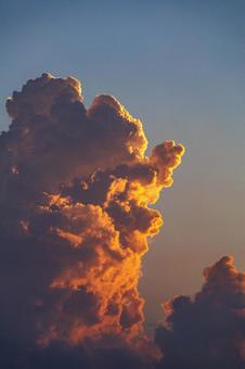 Golden cumulonimbus clouds illuminated by the setting sun, JPG