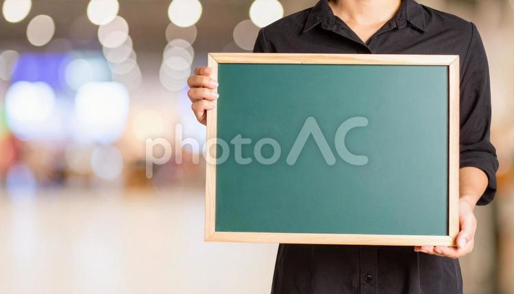 お知らせ　緑の黒板を持つ女性 案内,女性,手の写真素材