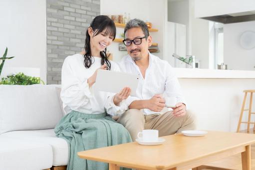 リビングでタブレットを見るミドルの夫婦 夫婦,家族,ミドルの写真素材