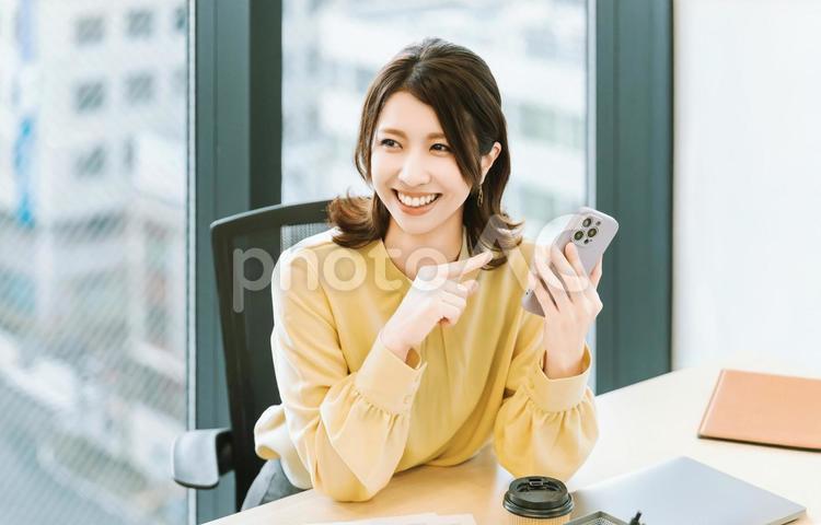 スマホを使う笑顔の女性・ビジネスウーマン 女性,スマホ,スマートフォンの写真素材