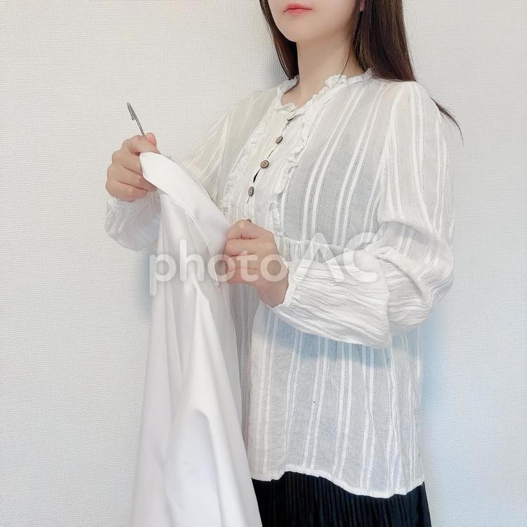 洗濯したシャツを持つ女性 女性,ポーズ,白の写真素材