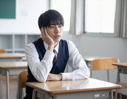 授業中に頭を抱えて悩む男子学生 授業中に頭を抱えて悩む男子学生の写真