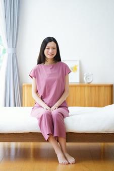 ベットに座りカメラ目線のロングヘアの女性 女性,ベッド,座るの写真素材