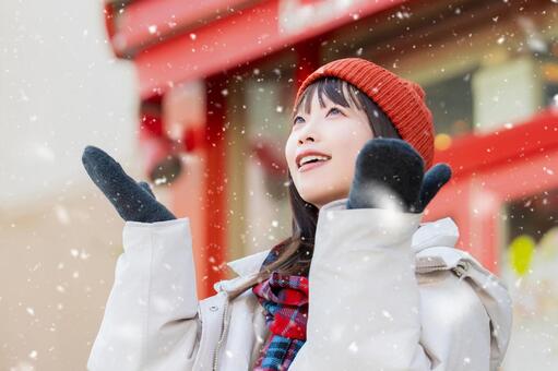 雪の降る冬の街角に立つ笑顔の女性 冬,雪,女性の写真素材