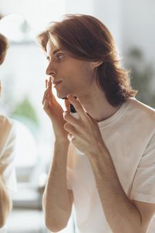 鏡を見ながらスキンケアしている男性 男性,外国人,欧米人の写真素材