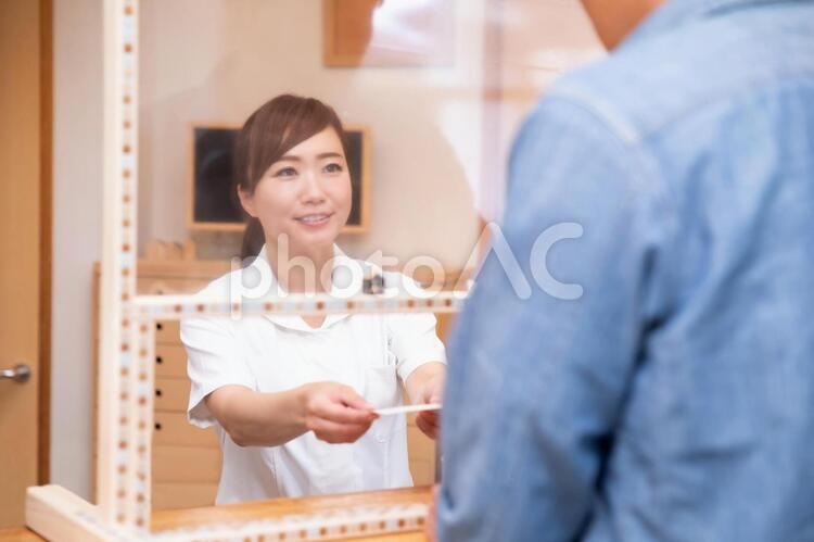 パーテーション越しに会話する医療スタッフ 医療事務,受付,問診表の写真素材