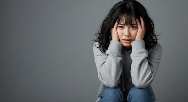 頭を抱えている女性じょの写真