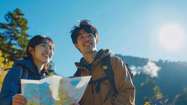 地図を見ながら登山するカップル 地図を見ながら登山するカップルの写真