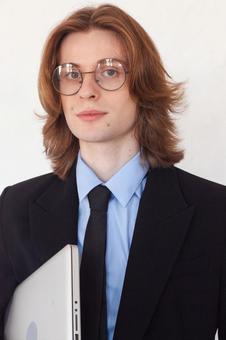 パソコンを待ちカメラ目線の長髪男性 男性,外国人,ノートパソコンの写真素材