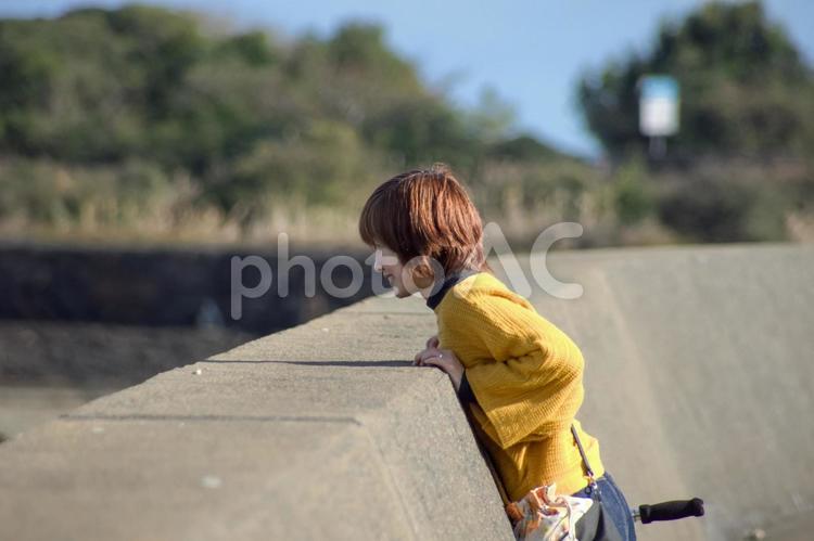 R＜人物＞秋の防波堤沿いを散歩する女性 女性,笑顔,散歩の写真素材