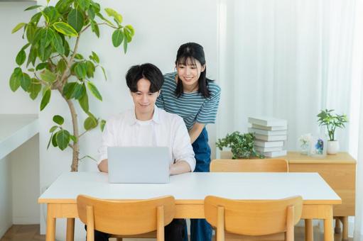 パソコンを見るカップル ノートパソコン,笑顔,カップルの写真素材