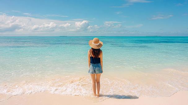 波打ち際で海を眺める女性の後ろ姿 波打ち際で海を眺める女性の後ろ姿の写真