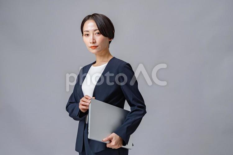 パソコンを持つ女性・グレーバック エージェントコンサル,アドバイザー,活動の写真素材