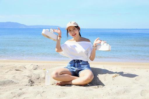 砂浜に座ってはしゃぐ女性 砂浜に座ってはしゃぐ女性 女性,海,夏の写真素材