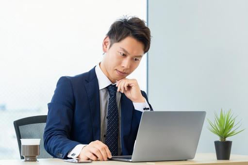 パソコンを使いながら悩む男性ビジネスマン パソコンを使いながら悩む男性ビジネスマン 男性,パソコン,悩むの写真素材
